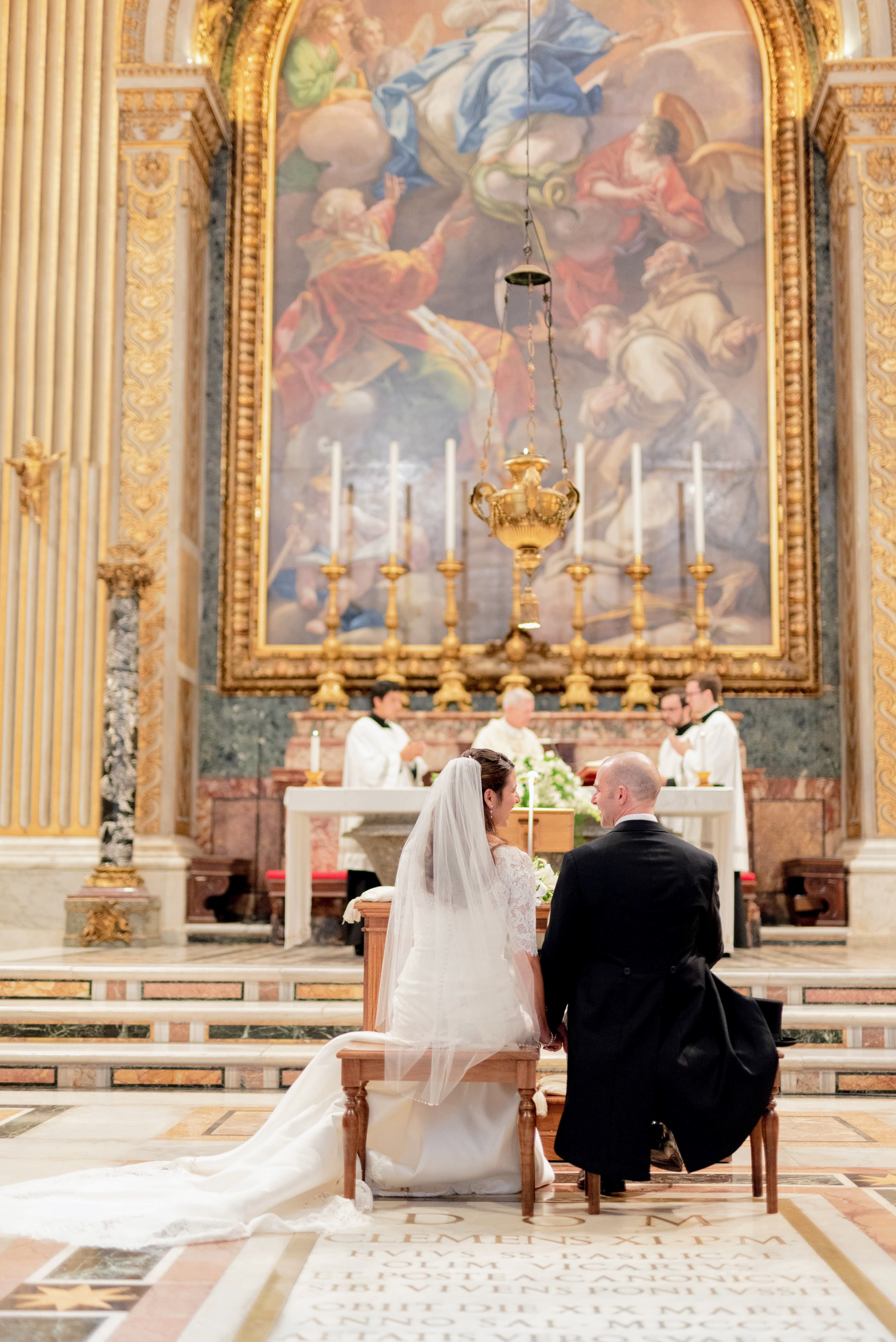 Couple at the altar during a Catholic wedding at St. Peter's Basilica